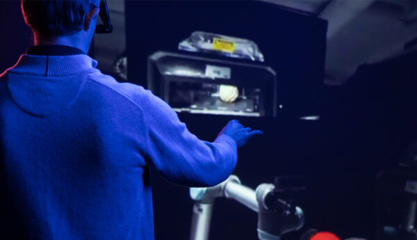 Researcher using AR headset to direct a robotic arm.