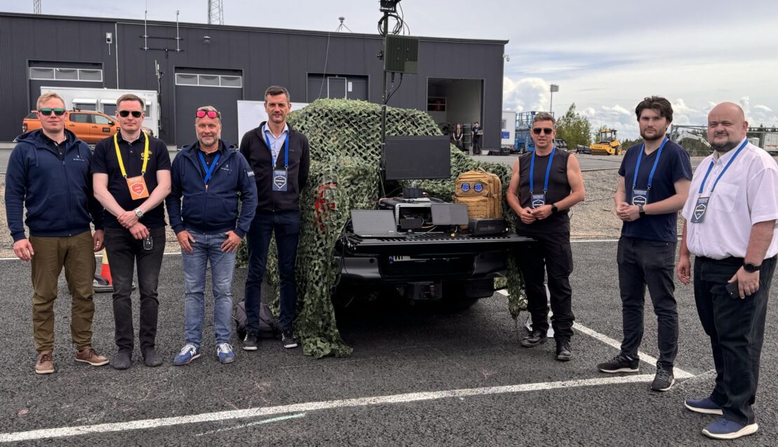 IS-Wireless and 6G Test Centre representatives beside a vehicle-mounted communications system at OuluZone during LCI-X Crucible 2-26